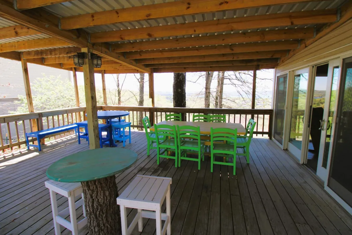 A cheerful outdoor dining area with colorful chairs, a wooden table, and an open view. The setting encourages group meals, stargazing, and relaxed social moments close to nature.